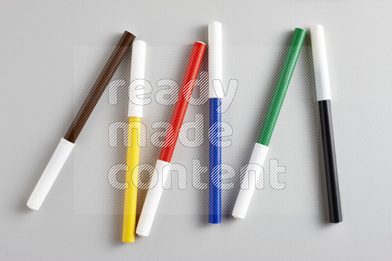 An arrangement of coloring pens in different colors on grey background