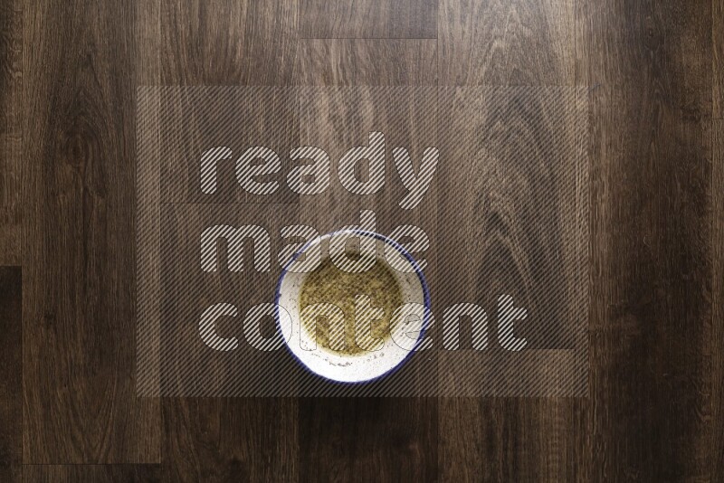 A bowl full of spices and salad dressing ingredients on wooden background