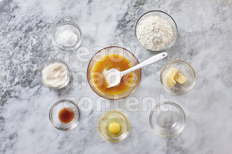 Cookies step by step with its ingredient, flour, butter, brown sugar, egg, vanilla extract, white sugar, chocolate chips and baking soda on grey marble background