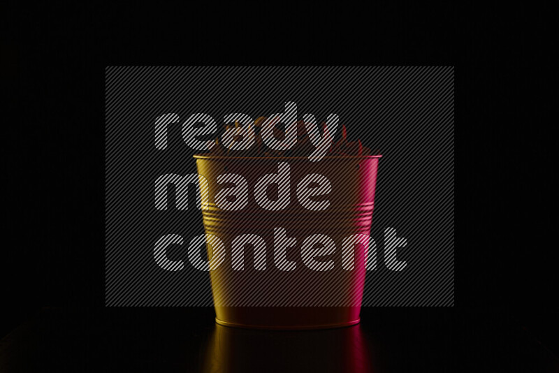 A plant pot with colored rim light against black background