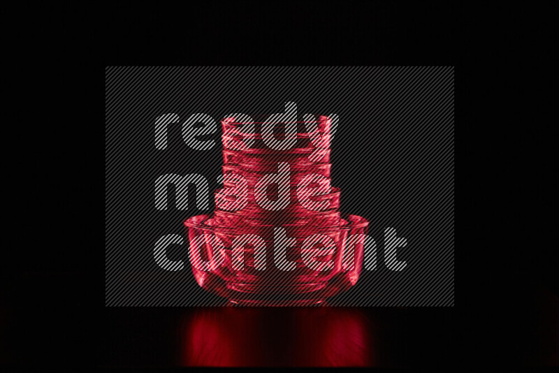 Glassware with rim light in red against black background