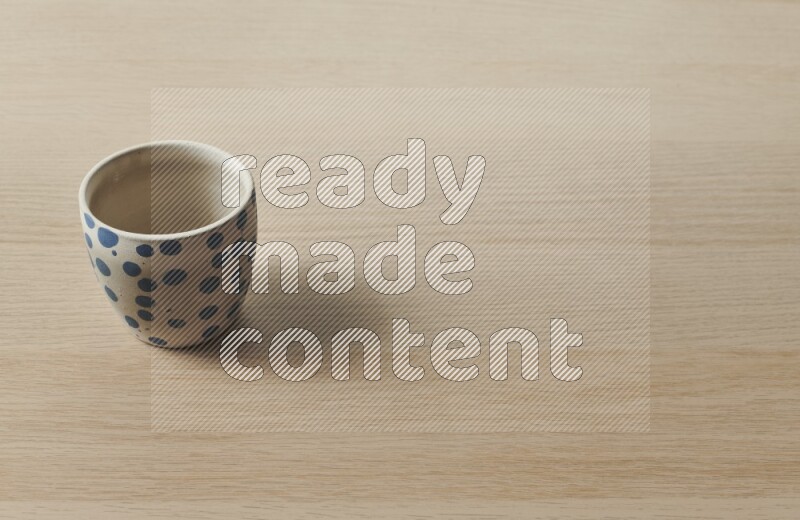 A pottery cup on light wooden background
