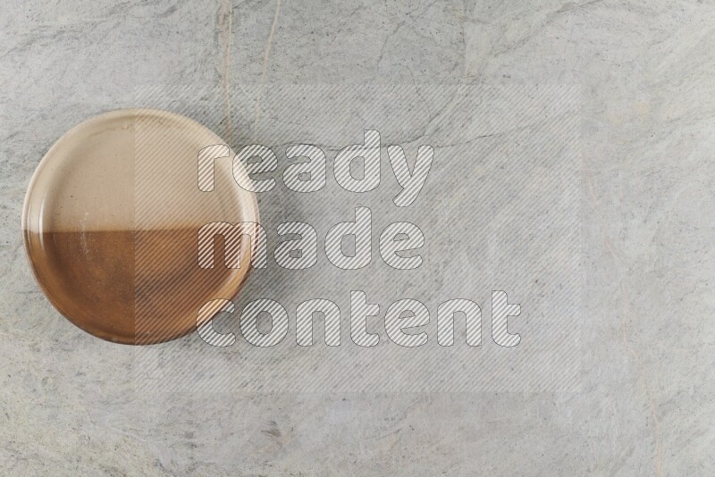 A multicolored pottery oven bowl on grey marble background