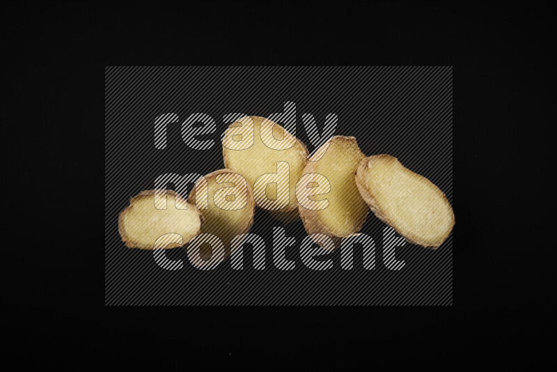 Fresh ginger slices on black background