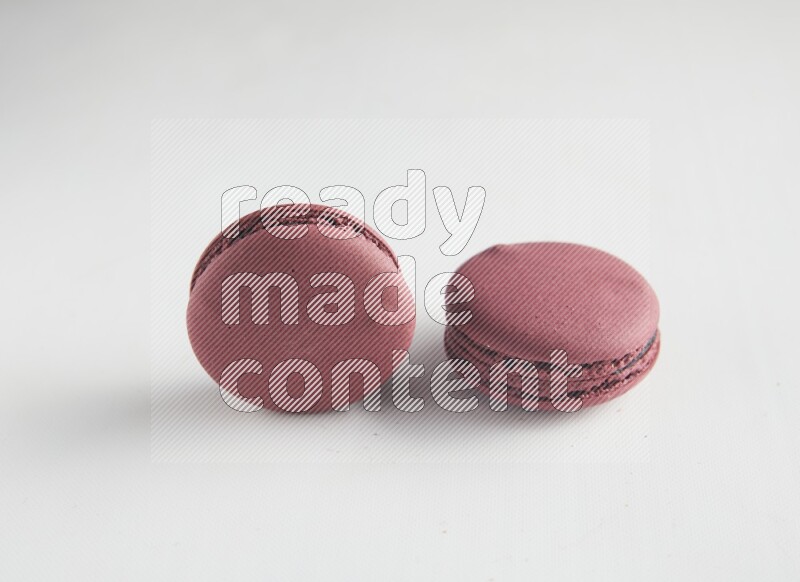 45º Shot of two Red Cherry macarons on white background