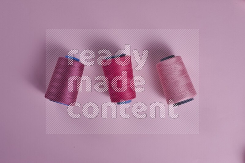 مجموعة من أدوات الخياطة والتفصيل زهرية اللون على خلفية زهرية