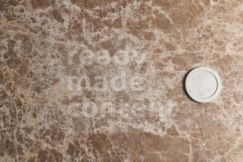 A decorative coaster on beige marble background