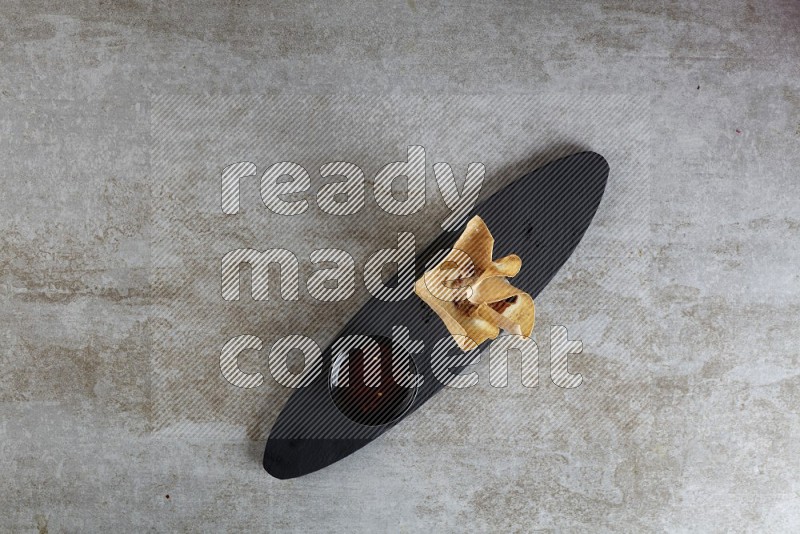wonton cups with soy sauce ramkin on oval slate on grey textured counter top