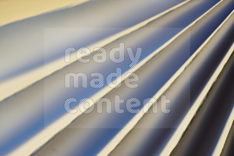 صورة تقدم نمط تجريدي ورقي من الخطوط المائلة بدرجات اللون الأزرق والذهبي