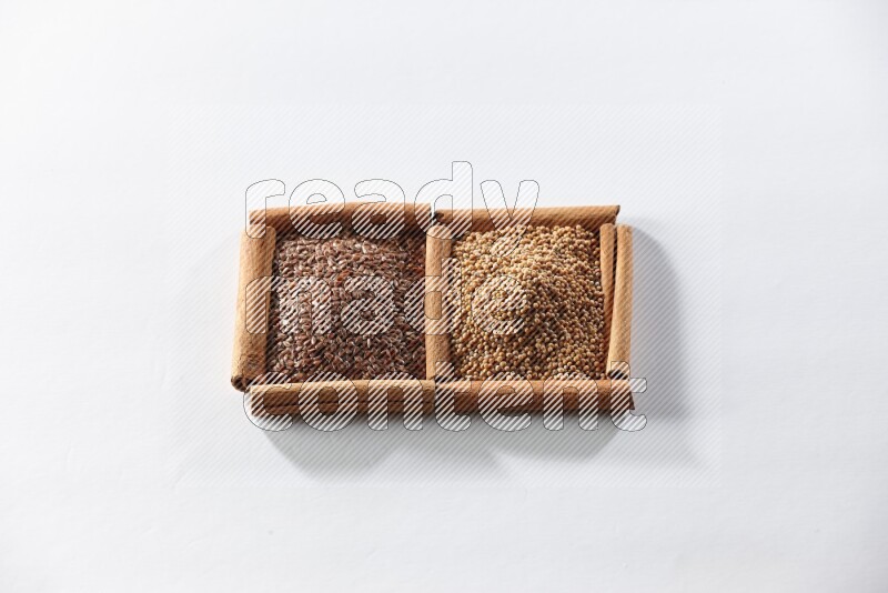 2 squares of cinnamon sticks full of mustard seeds and flaxseeds on white flooring