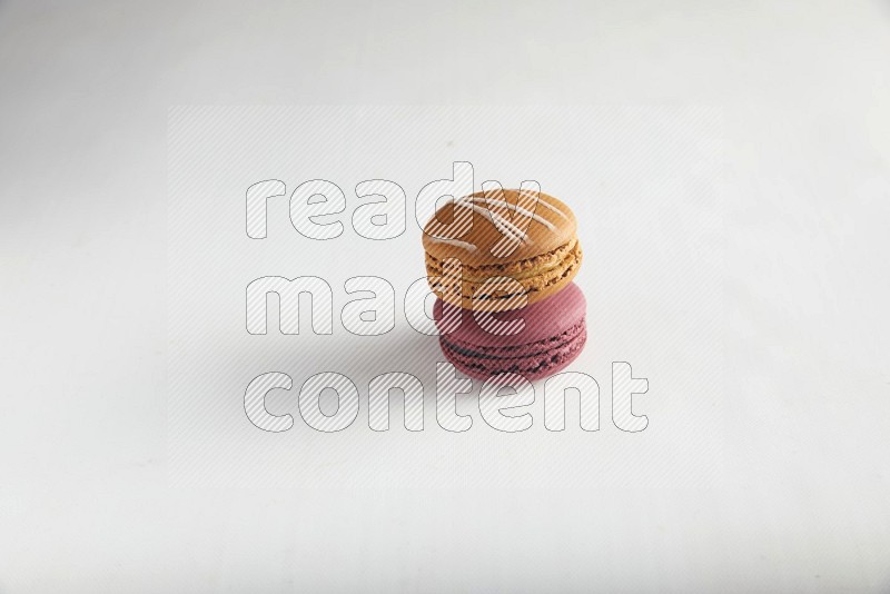 45º Shot of of two assorted Brown Irish Cream, and Red Cherry macarons on white background