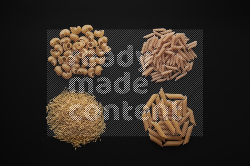 Different pasta types in bunches on black background