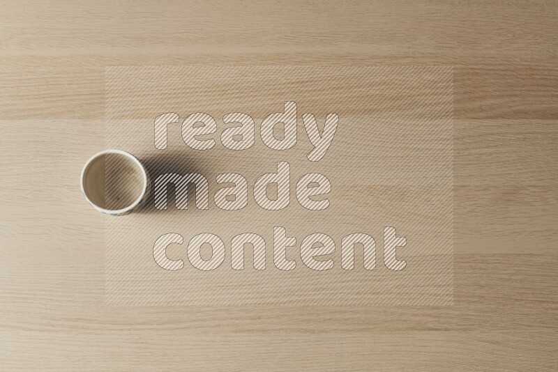 A pottery cup on light wooden background