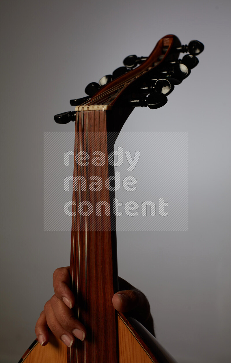 a hand intracting with a wooden brown Oud