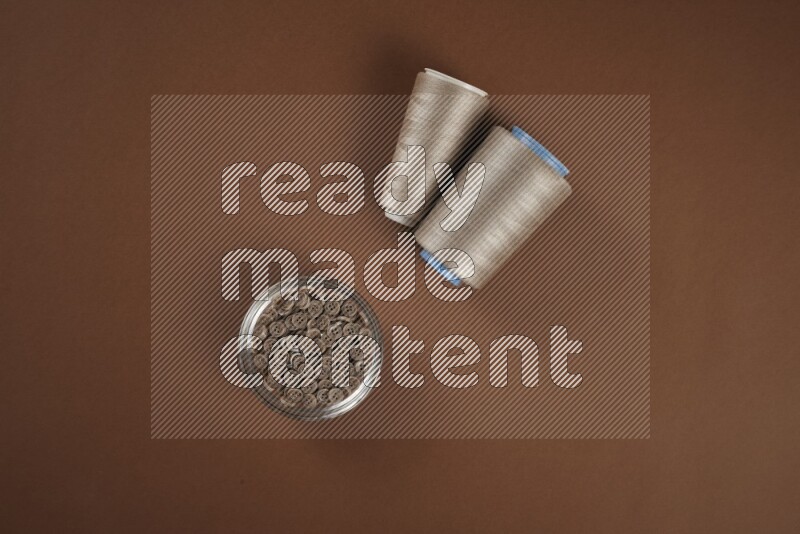 مجموعة من أدوات الخياطة والتفصيل بنية اللون على خلفية بنية