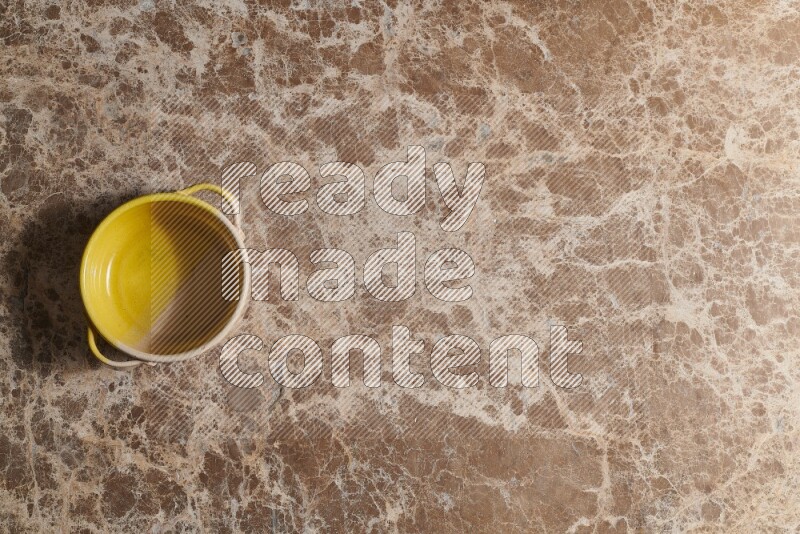 A multicolored pottery bowl on beige marble background