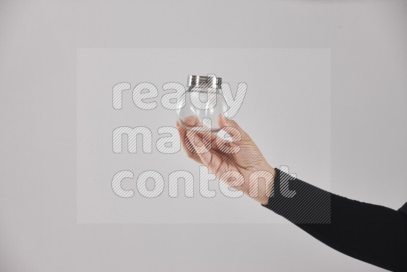 A woman in black abaya holding different glassware in different positions