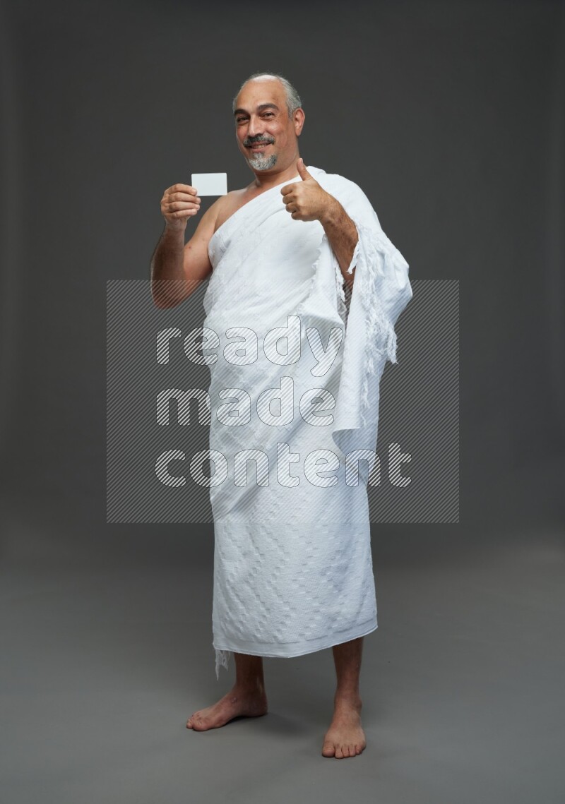 A man wearing Ehram Standing holding ATM card on gray background