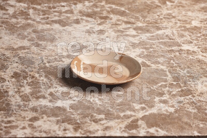 A multicolored pottery plate on beige marble background