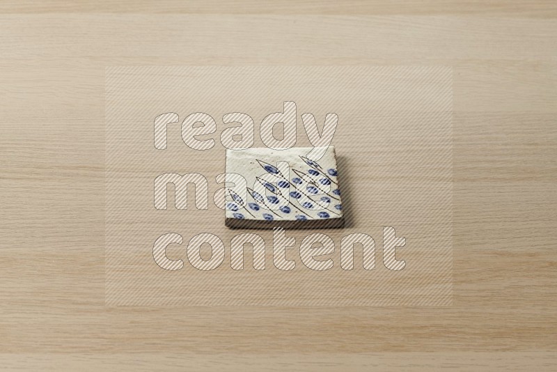Pottery coaster\ tile on oak wooden flooring, 45 degrees