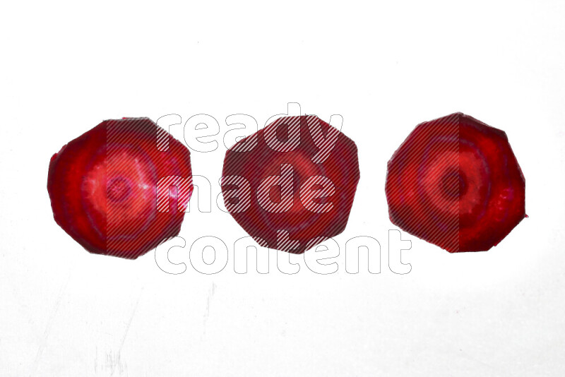 Beet slices on illuminated white background