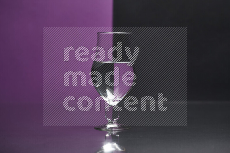 The image features a clear glassware filled with water, set against purple and black background