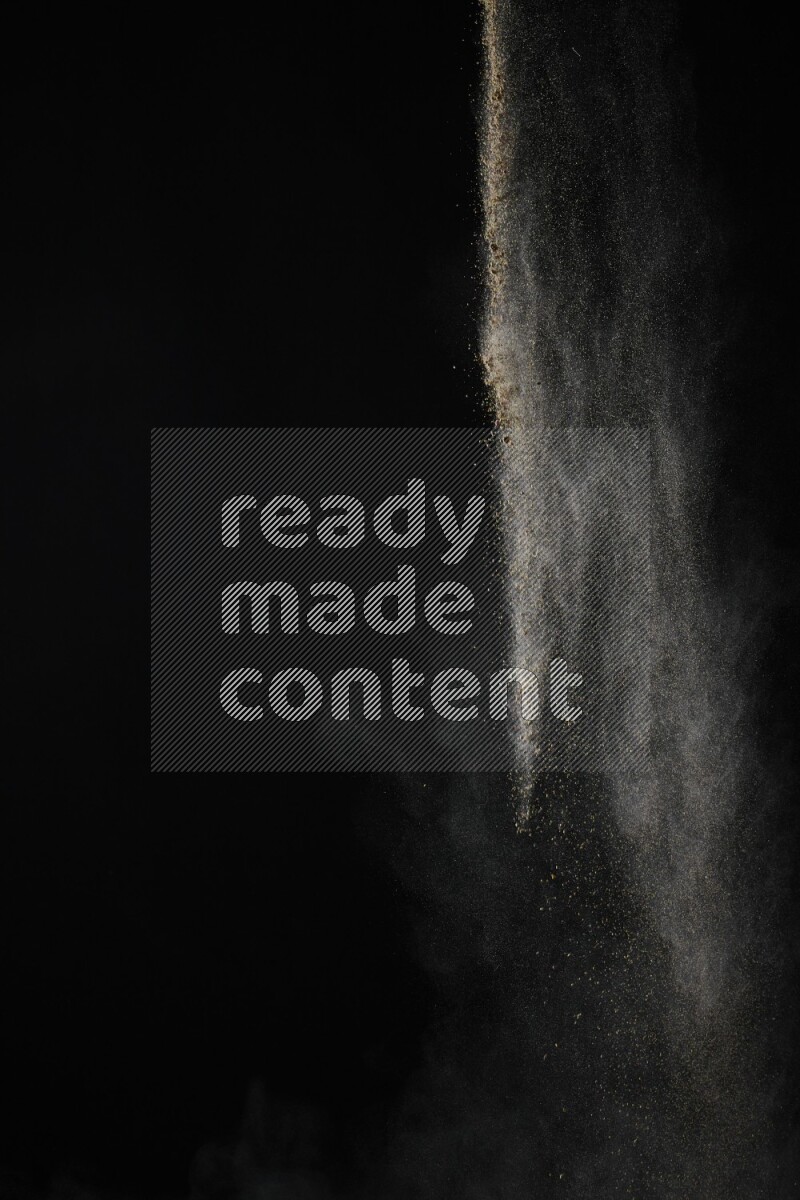 A side view of brown powder explosion on black background