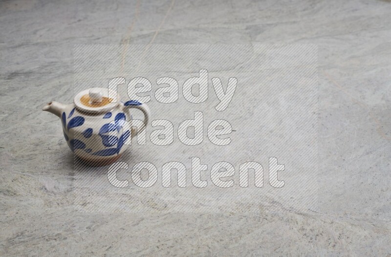 A pottery teapot on grey marble background