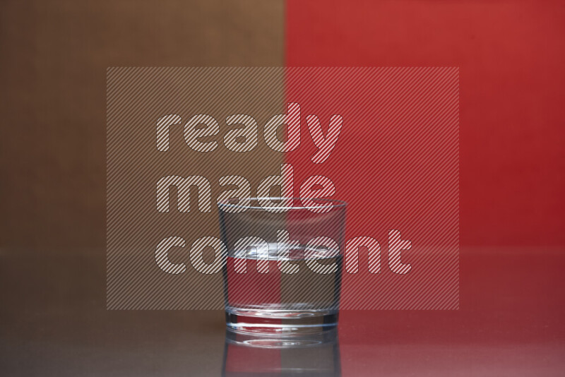 The image features a clear glassware filled with water, set against brown and red background