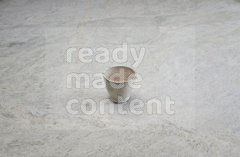 A multicolored pottery Cup on grey marble background
