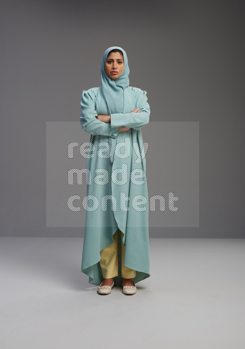 Saudi Woman wearing Abaya standing with crossed arms on Gray background