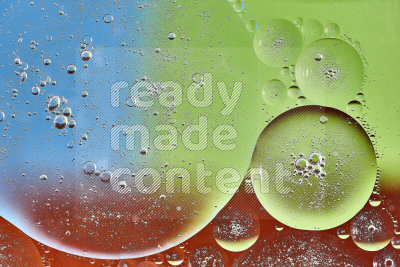 Close-ups of abstract oil bubbles on water surface in shades of orange, green and blue