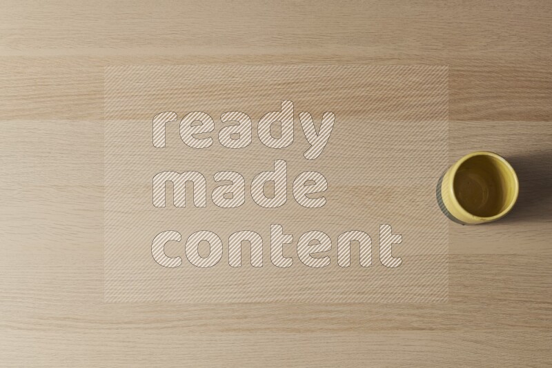 A multicolored pottery cup on light wooden background