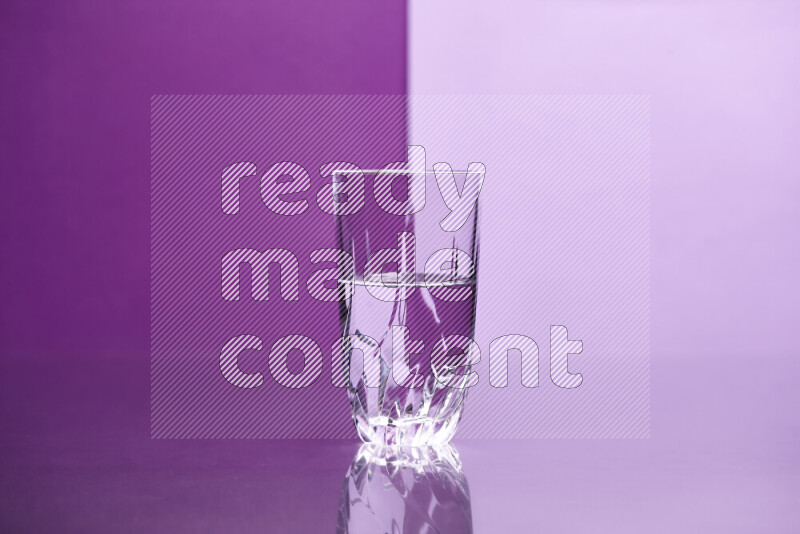 The image features a clear glassware filled with water, set against purple and light purple background