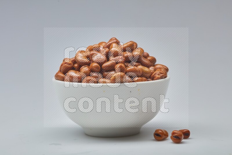 Close up shot of cooked fava beans (foul) in a container on white background