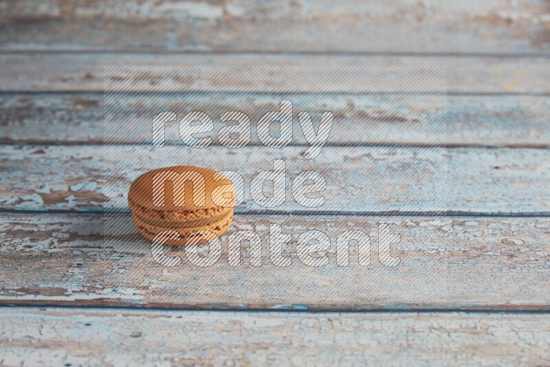 45º Shot of Brown Maple Taffy macaron on light blue wooden background