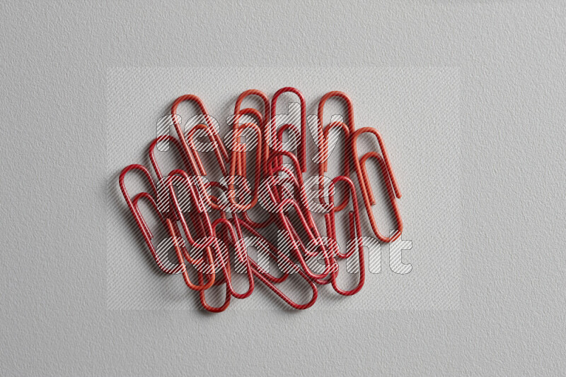 Red paper clips isolated on a grey background
