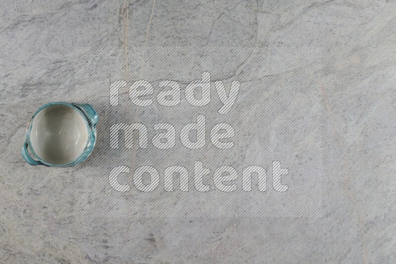 وعاء فخاري متعدد الألوان على خلفية من الرخام الرمادي