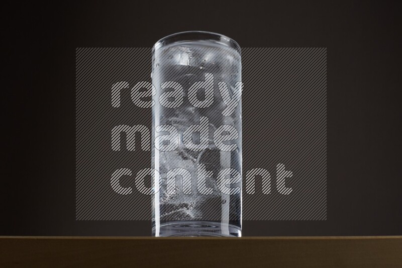 Low angle shot of a glass of water and ice on grey background