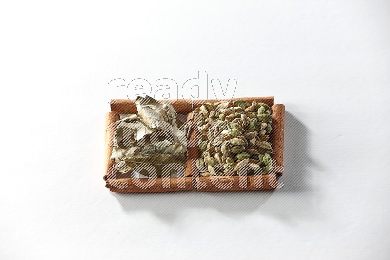 2 squares of cinnamon sticks full of cardamom and bay laurel leaves on white flooring