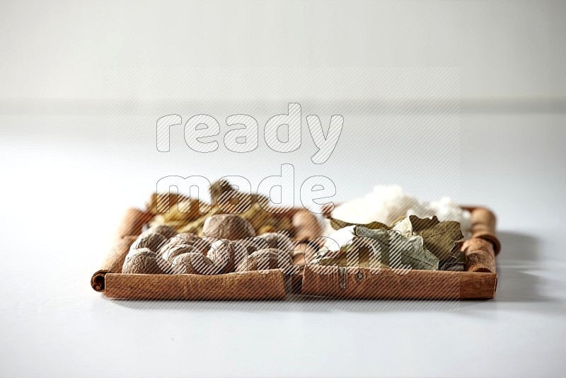 4 squares of cinnamon sticks full of salt, bay laurel, nutmeg, turmeric on white flooring