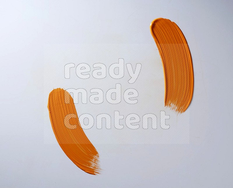An orange curved painting brush stroke on a white background