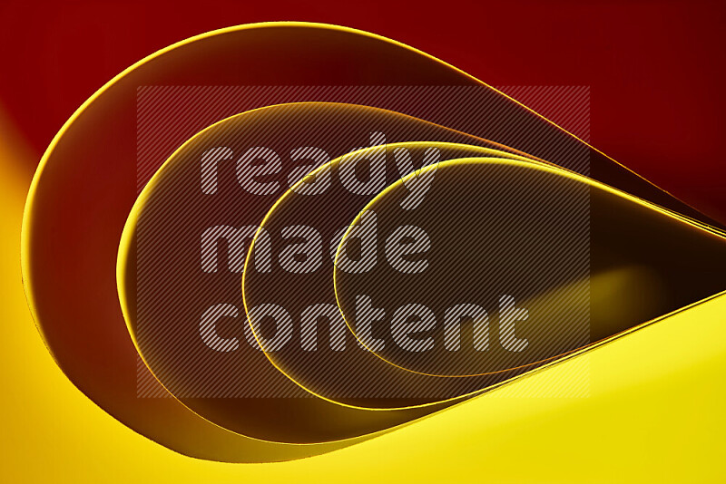 An abstract art of paper folded into smooth curves in yellow, brown and red gradients