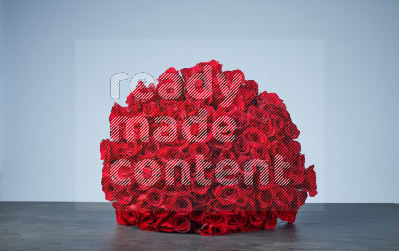 كرة من الورود الحمراء النابضة بالحياة مرتبة بإحكام على خلفية من الرخام الأسود