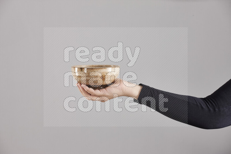 A woman in black abaya holding different pottery essentials in different positions