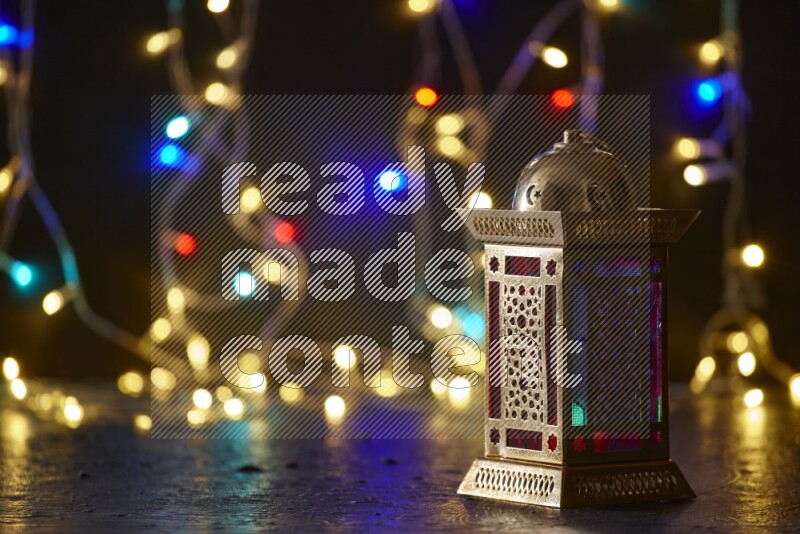A traditional ramadan lantern surrounded by glowing fairy lights in a dark setup