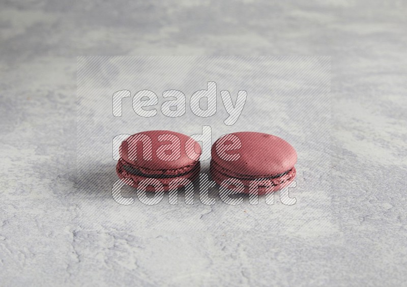 45º Shot of two Red Cherry macarons  on white  marble background