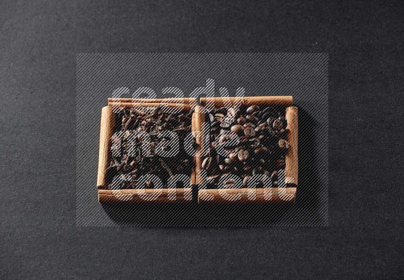 2 squares of cinnamon sticks full of coffee beans and cloves on black flooring