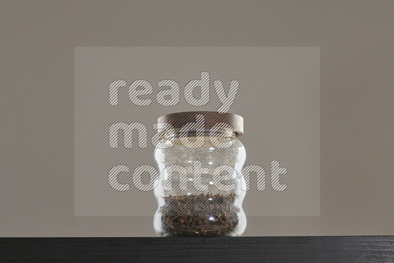 Dried basil in a glass jar on black background