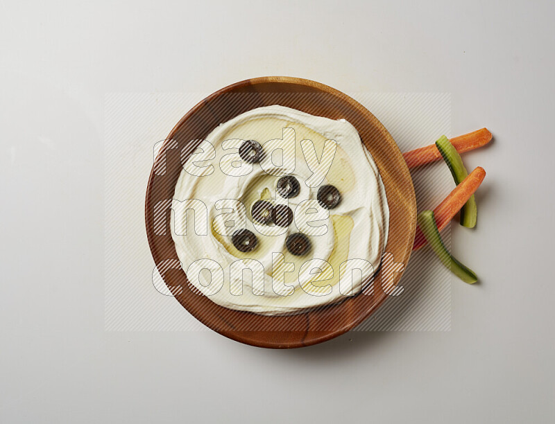 Lebnah garnished with sliced olives in a wooden plate on a white background